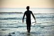 picture of a young surfer walking on the water
