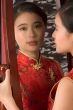 Chinese girl in red cheongsam by mirror