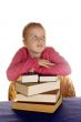 young little girl above a stock of books