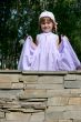 child in gown standing on wall