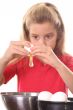 little girl cracking egg to make cookies