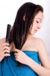 Woman is brushing her hair and looking down