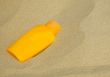 Sunscreen bottle on sand