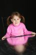 Child on dark background, keeps in hand reflector