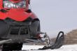 Red snowmobile in winter mountains