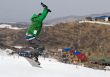 Snowboarder jumping at contest in mountains