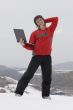 Happy teens with laptop in winter mountains