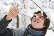 Teens boy with snown branch in winter