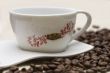 Cup of coffee and grains over sackcloth