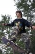 Teenager in Camouflage jumping by Skateboard