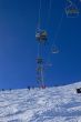 Chairlifts & skiers, against blue sky