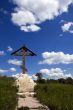 Orthodox cross over meadow and blue sky
