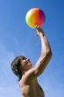 Happy sport build teenager boy with ball in beach