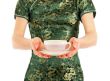 Woman in Chinese dress offering a cup of tea