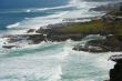 Surf with homes along rugged coastline