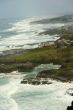 Surf with homes along rugged coastline
