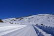 Tracks on snow covered road in mountain