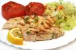 Grilled white fish and tomato with fresh salad on plate. Isolate