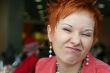 red haired woman is smiling in cafe