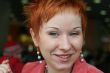 red haired woman is smiling in cafe