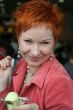 woman eating ice cream in cafe and smiling happy