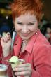 woman eating ice cream in cafe and smiling happy