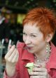 woman eating ice cream in cafe and smiling happy