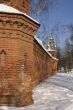 Old tall red brick wall of with decorated towers