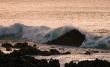 Crashing waves on rock in sunset