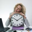 Sleepy woman with large clock
