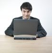 Businessman smiling behind computer