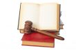 Wooden gavel and old opened law book