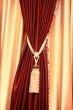 Purple velvet curtain with golden tassel. Close-up