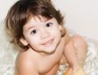 smiling pretty little girl sitting in the bath