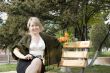 Women with bunch of flowers at the bench in park