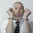 Man and handcuffs sticking out his tongue