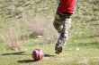 Men teens playing soccer in green grass