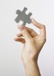 Hand holding puzzle piece