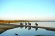 bicyclists between sky & water