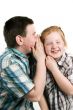 boy is whispering in girls ear
