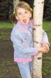 The girl in a blue dress plays with birches