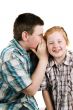 boy is whispering in girls ear