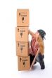 Girl trying to lift a stack of cardboard boxes