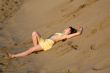 blond girl lying on the beach