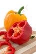 Red and yellow paprika on bamboo cutting board.