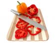 Red and yellow paprika on bamboo cutting board.