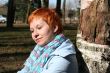 red haired woman is sitting near tree