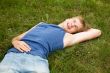 Smiling boy lying on the green grass