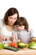 mother and daughter cooking at the kitchen