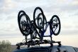 Three sports bicycles over jeep at sunrise in trip